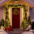 Front door framed with the lit garland, wreath and entrance trees