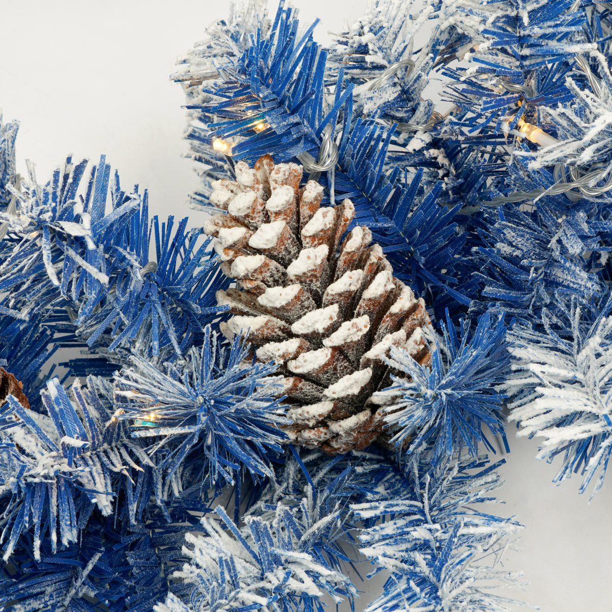 Blue flocked branch detail with a pine cone