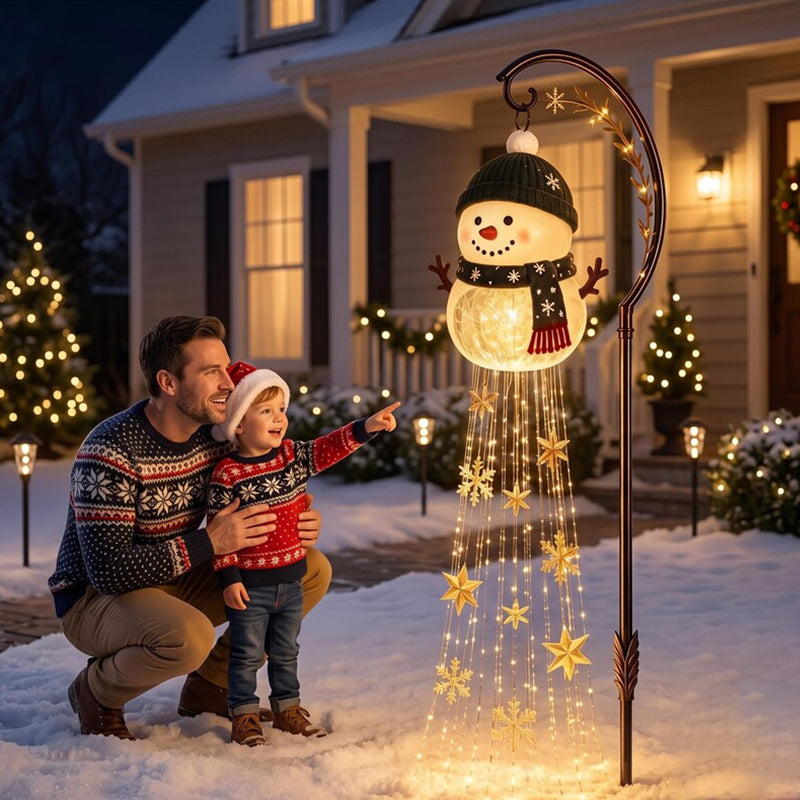 Father and child pointing at the hanging snowman garden light
