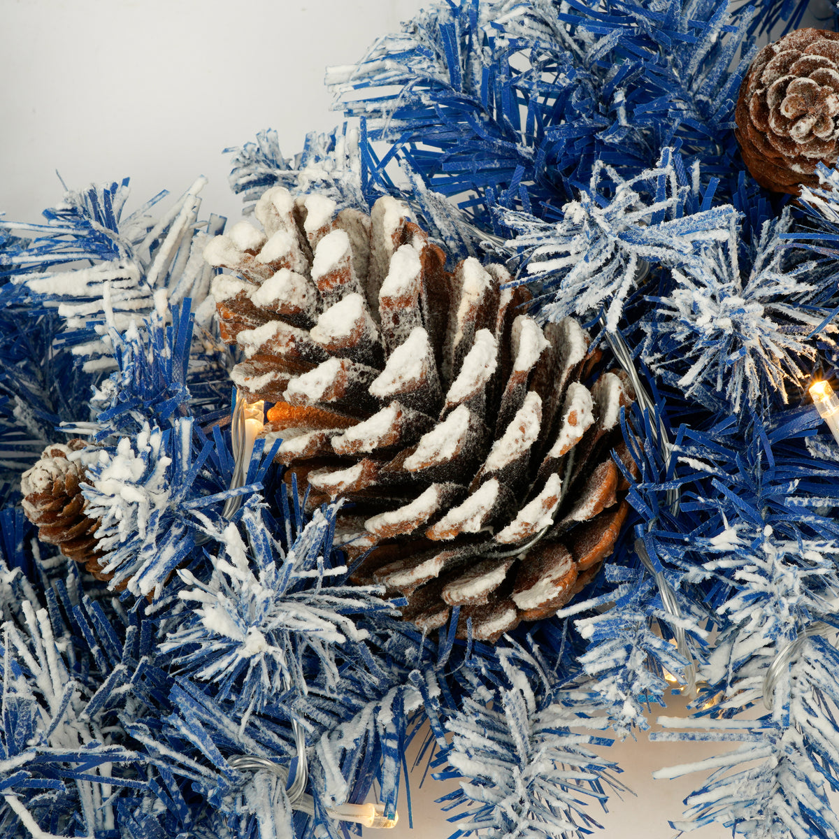 Pine cone detail on the blue flocked Christmas tree