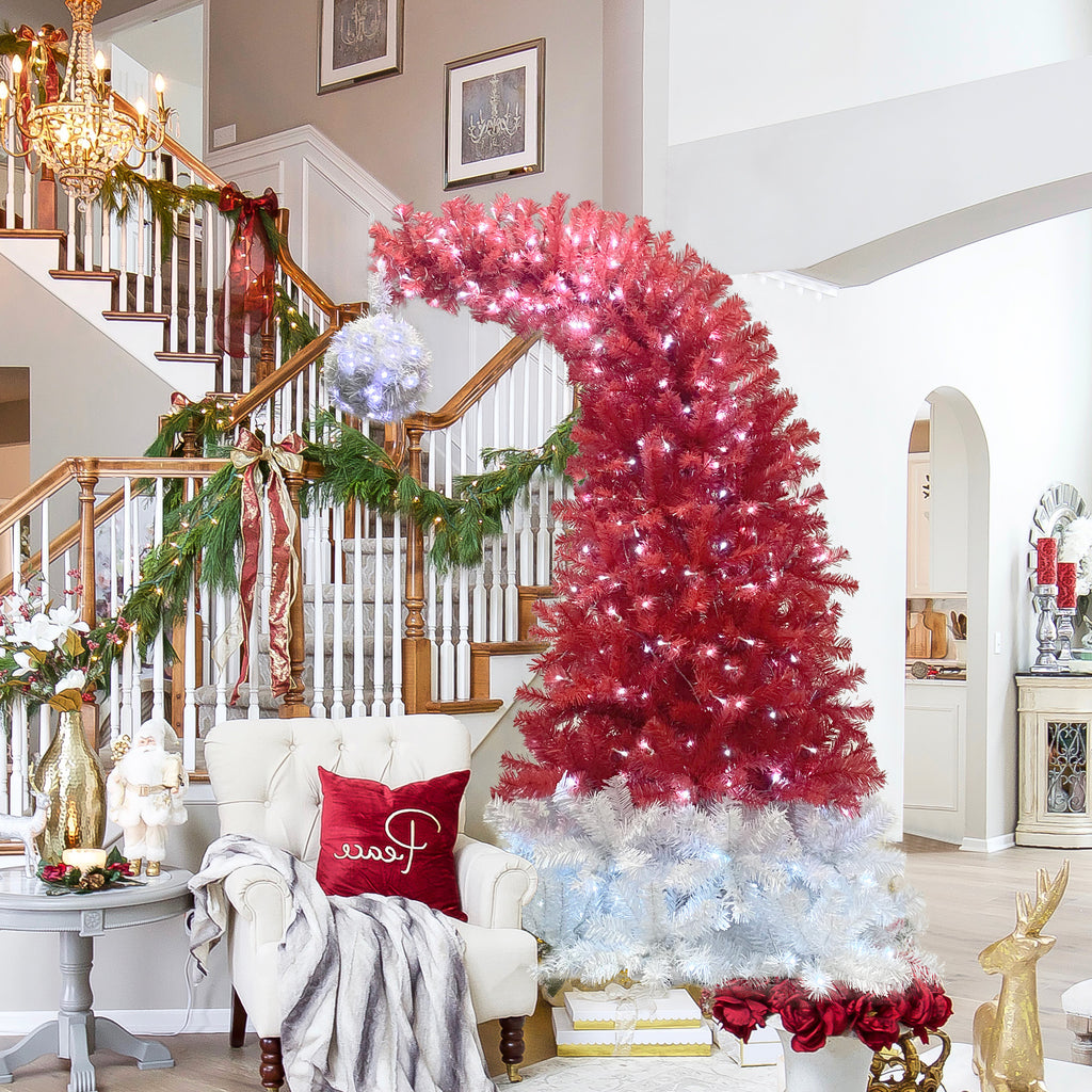 Santa hat Christmas tree by a staircase with garland