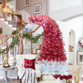 Santa hat Christmas tree by a staircase with garland
