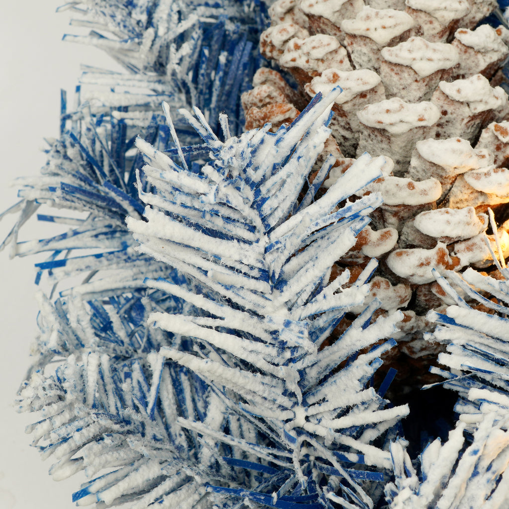 Close-up of snow-dusted blue branches and pine cones