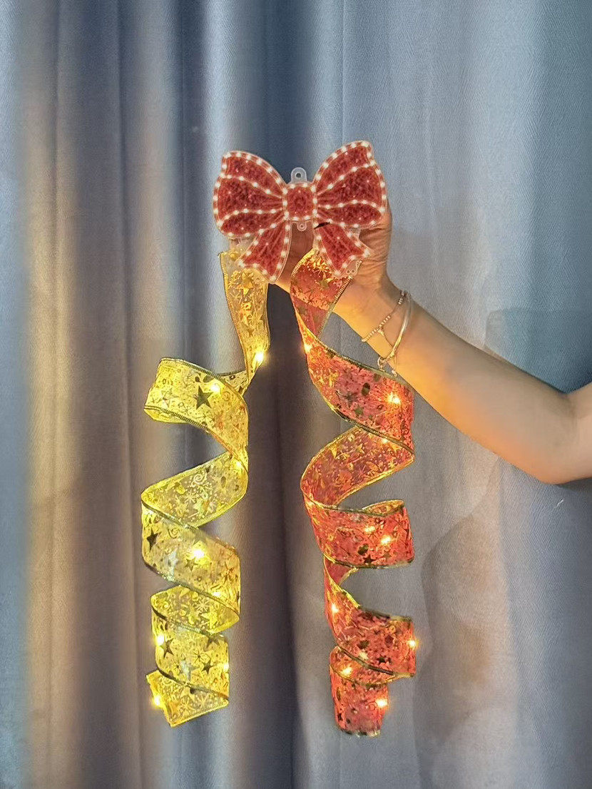 Bow LED hanging decorations in yellow and red, held in hand