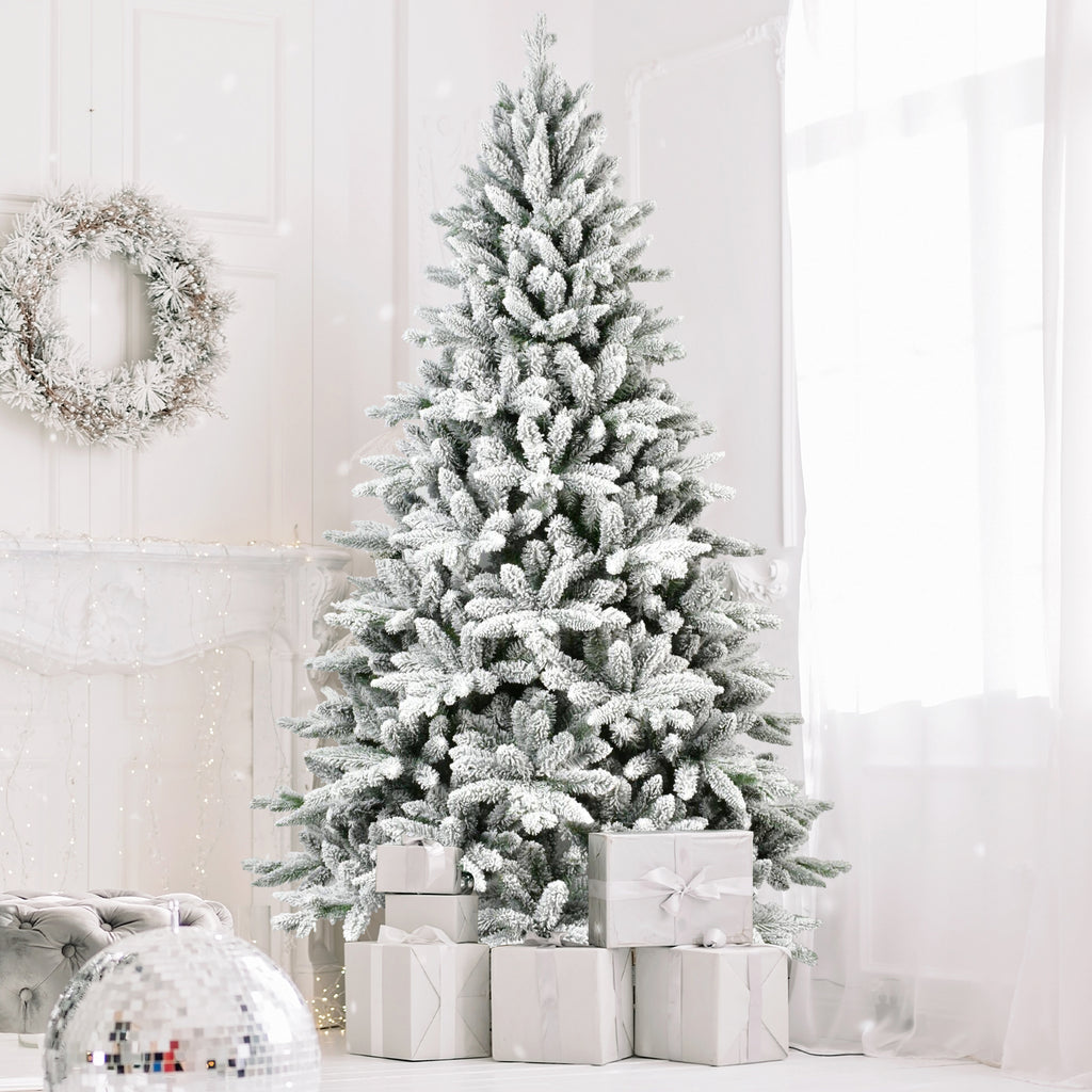 Snow-flocked Christmas tree with presents in a bright room