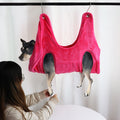Dog grooming hammock in pink being used for a nail trim