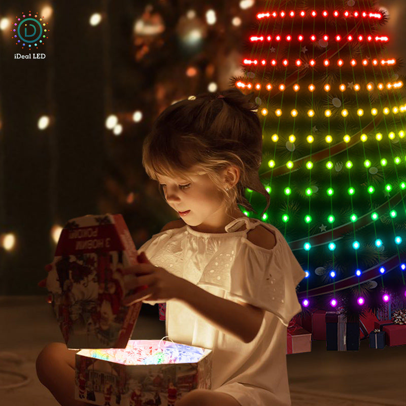 Child opening a gift beside a tree lit with smart colour-changing lights