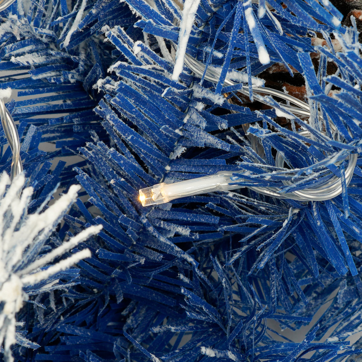 Warm white LED bulb among blue branches