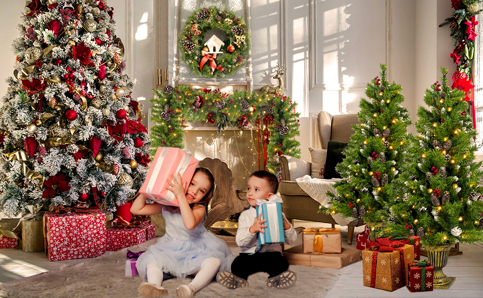 Kids with presents beside the entrance trees and a big Christmas tree
