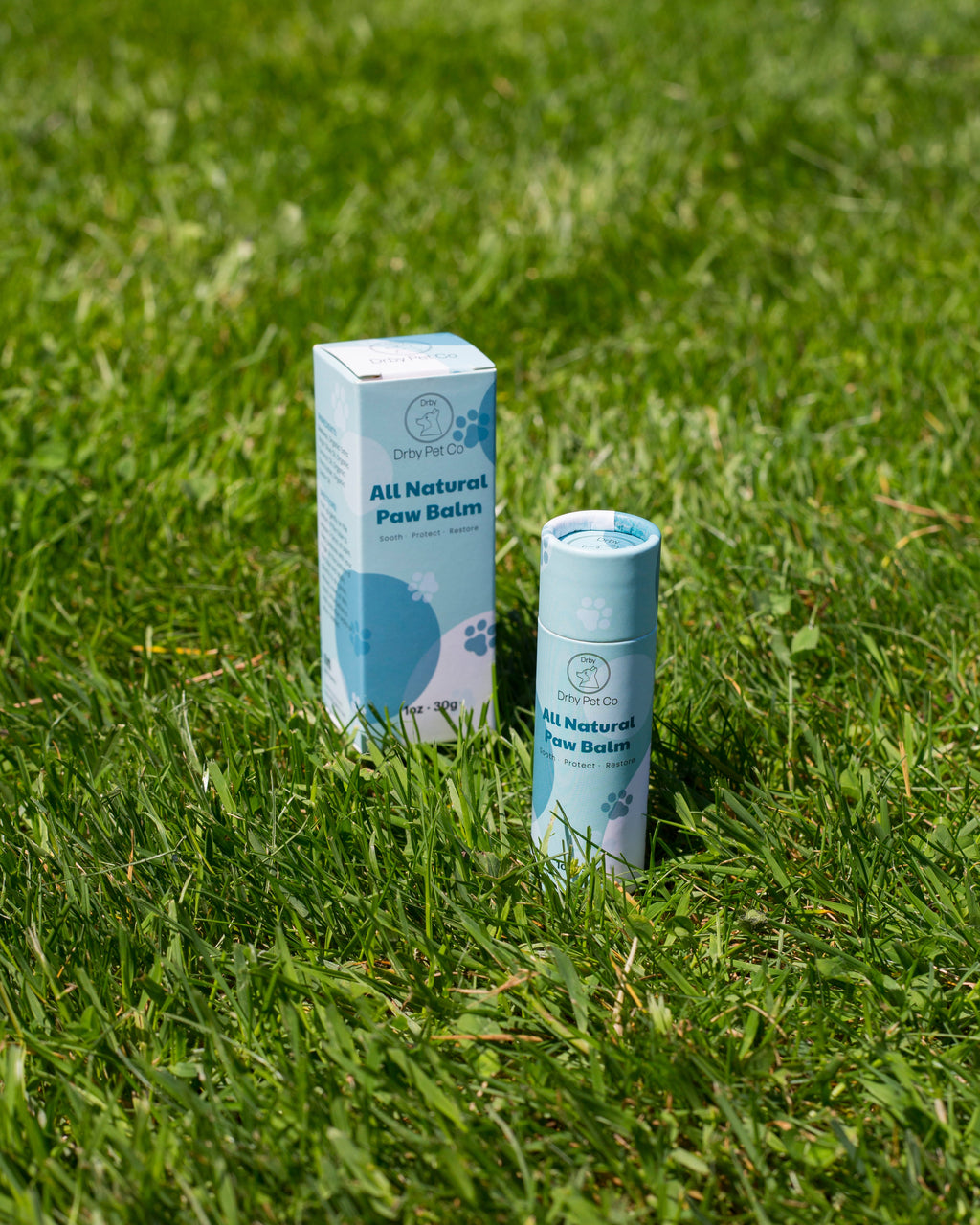 Drby all natural paw balm box and push-up stick on grass