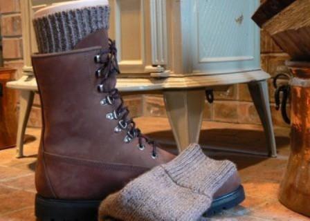 Superwarm alpaca socks next to a winter boot by a wood stove by DealSpark